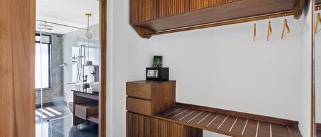A modern bathroom with a wooden vanity, a towel rack, and a shoe rack.