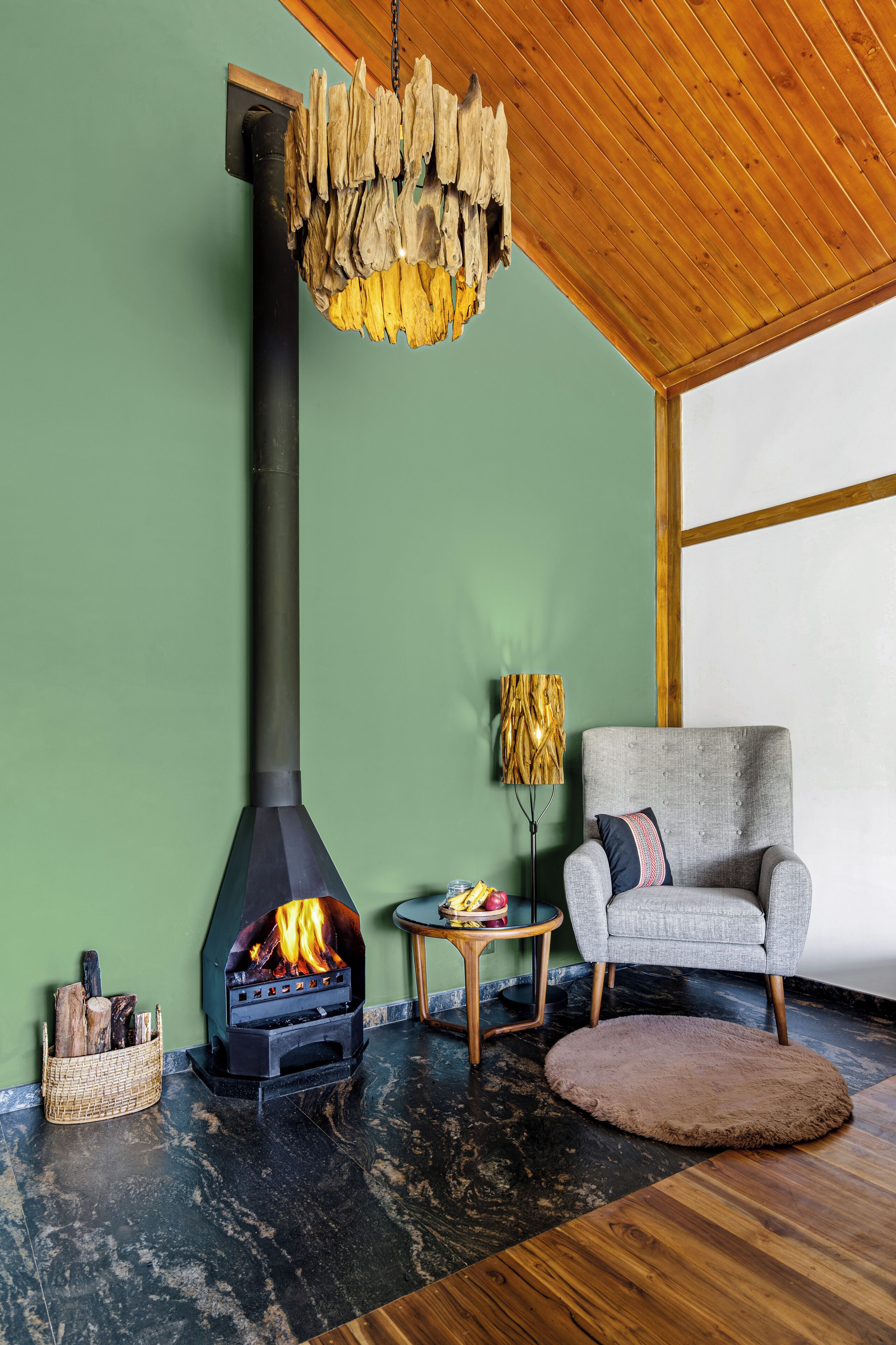 Een moderne woonkamer met een open haard, een comfortabele fauteuil en een houten plafond.