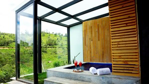 A modern spa area with a glass enclosure, a wooden slatted wall, and a hot tub. - WelcomHeritage Ayatana Ooty (Coonoor)