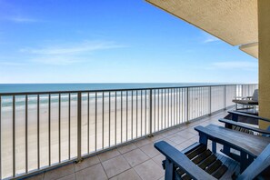 Un balcon avec vue sur la plage et l’océan.