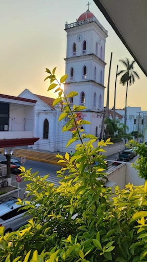 A church with a bell tower and a red dome, surrounded by greenery and palm trees. - Hotel Florida de Tuxpan  (Tuxpan)
