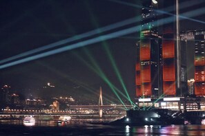 A nighttime cityscape with illuminated buildings and a bridge. - Jinyue Business Hotel (Chongqing)