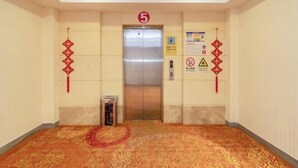 An elevator with a number 5 sign above it, a red decorative hanging, and a warning sign on the wall. - Nan'an Furong Hotel (Guoguang High School Meishan Bus Station) (Nan'an)