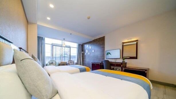 A hotel room with two beds, a desk, a chair, a TV, and a window with a view. - Nan'an Furong Hotel (Guoguang High School Meishan Bus Station) (Nan'an)