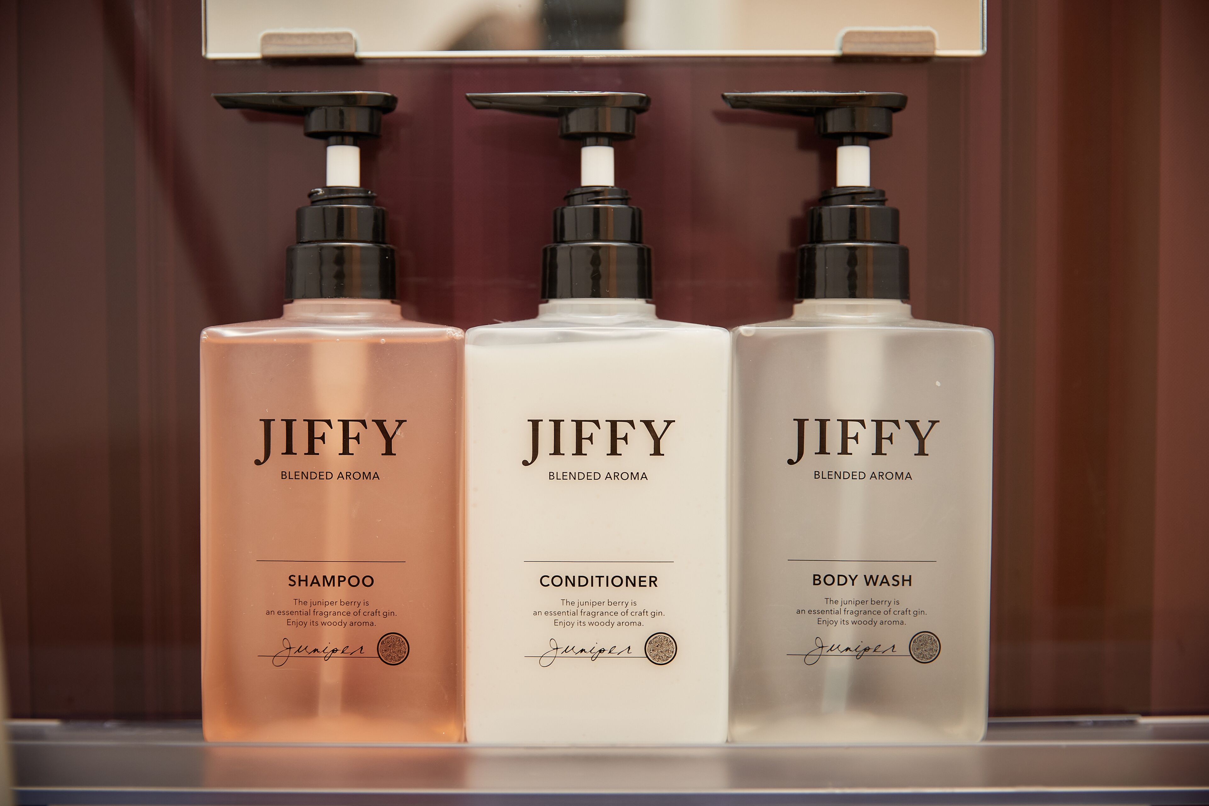 Three Jiffy products: shampoo, conditioner, and body wash, each with a pump dispenser.