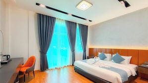 Una habitación de hotel con cama, escritorio y silla.