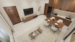 Una cocina moderna con comedor, televisor montado en la pared y puerta de madera.