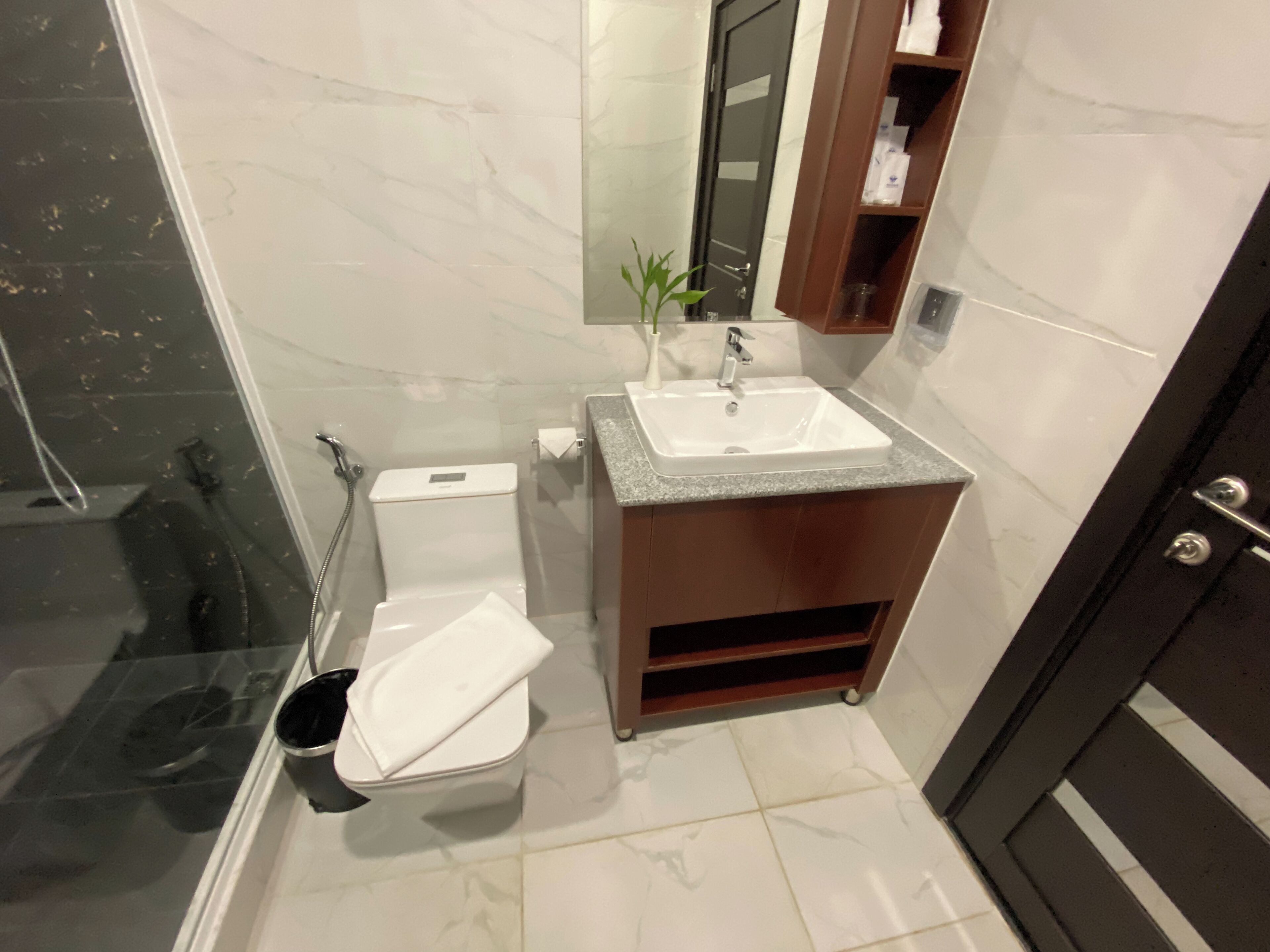 A modern bathroom with a toilet, sink, and shower.