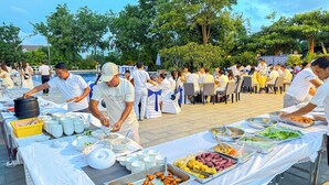 Montaje de bufé con diferentes opciones de comida y personal de servicio.