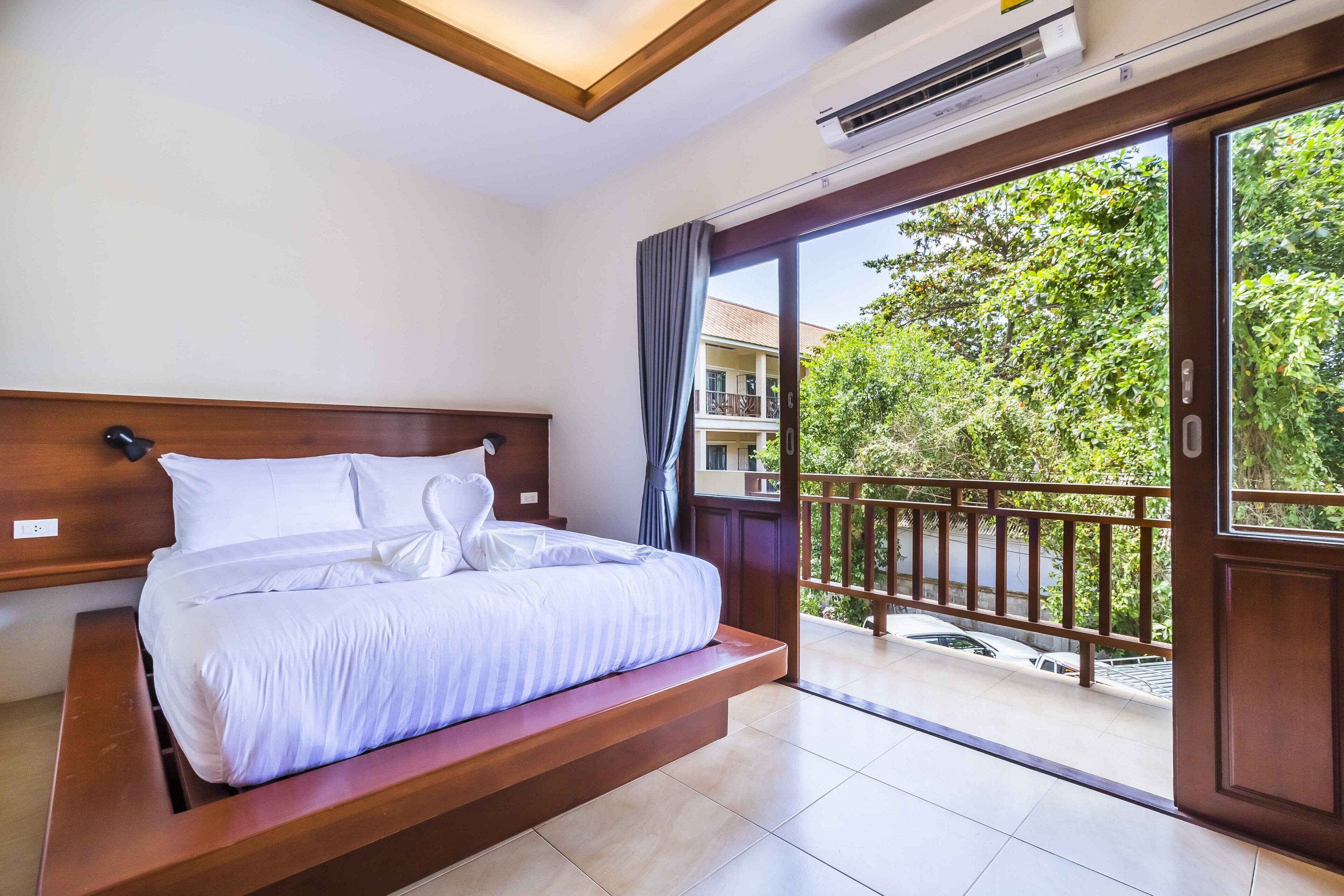 A hotel room with a bed, a balcony, and a view of the outside.