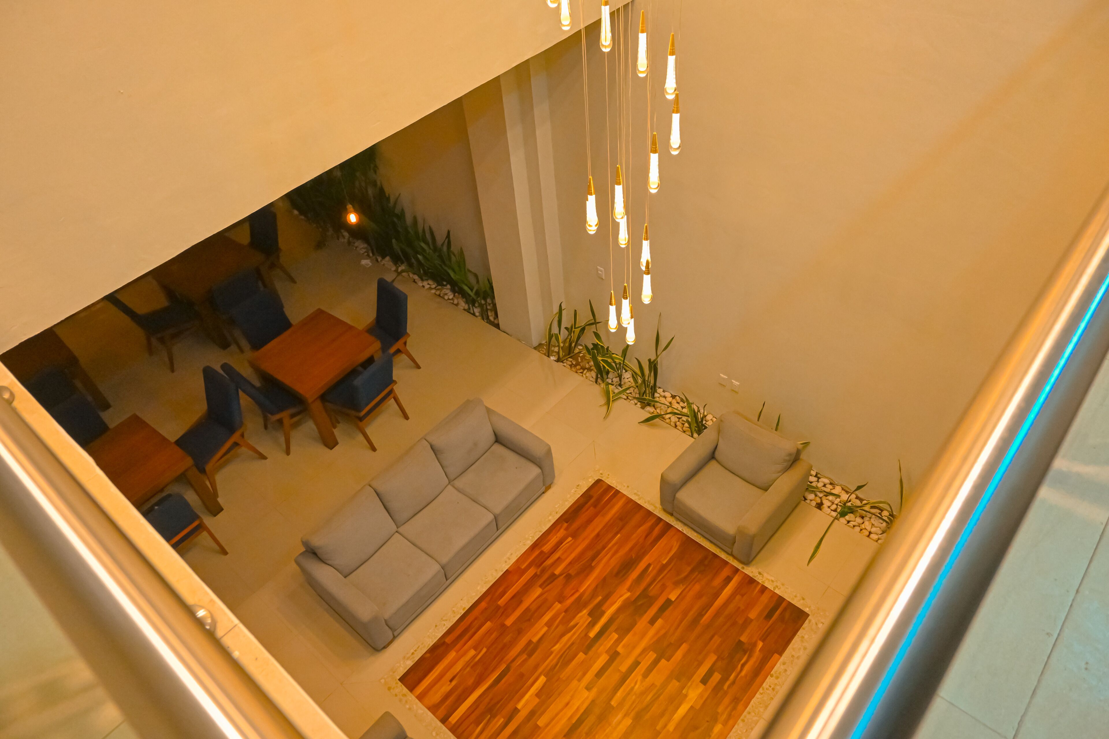 Ein modernes Interieur mit Essbereich, Sofas und Pendelleuchten.