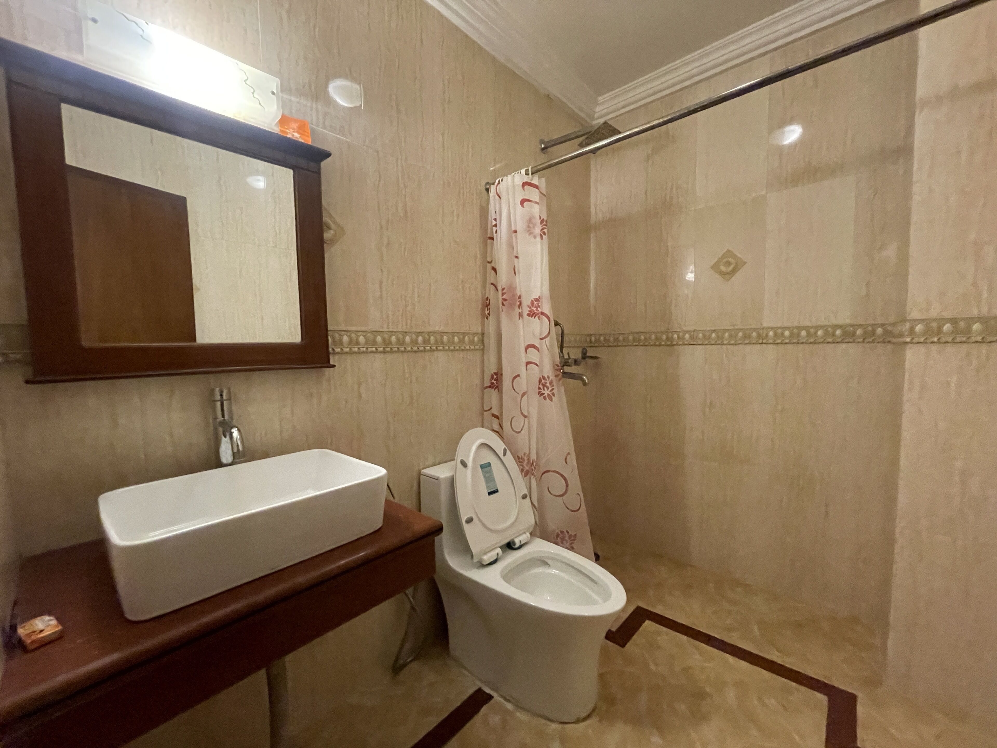 Un baño con un lavamanos blanco, inodoro y cortina de ducha.