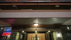 Une enseigne d’hôtel avec le nom « HÔTEL YETI » écrit en caractères gras.