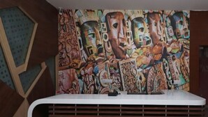 A reception area with a colorful mural on the wall and a modern reception desk. - Nirmalya plaza (Brahmapur)