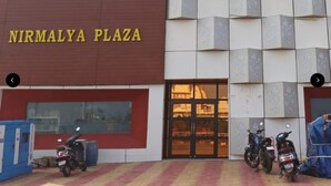 The exterior of Nirmalya Plaza with a large entrance and two motorcycles parked in front. - Nirmalya plaza (Brahmapur)
