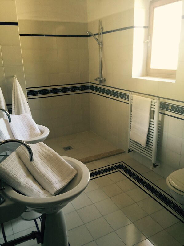 A bathroom with a shower, toilet, and sink.