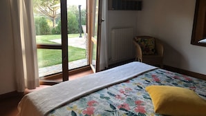 Una camera da letto con un letto, una sedia, una finestra e vista sull'esterno.