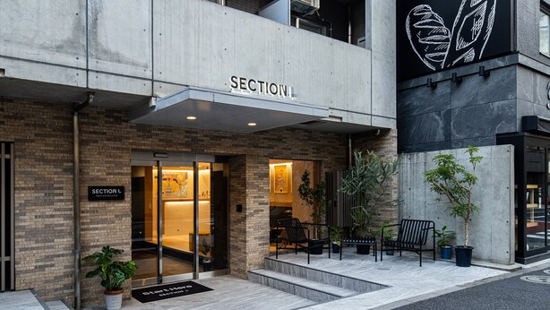 Une entrée moderne avec une enseigne indiquant « SECTION L » et un tapis sur lequel est écrit « Début ici ».