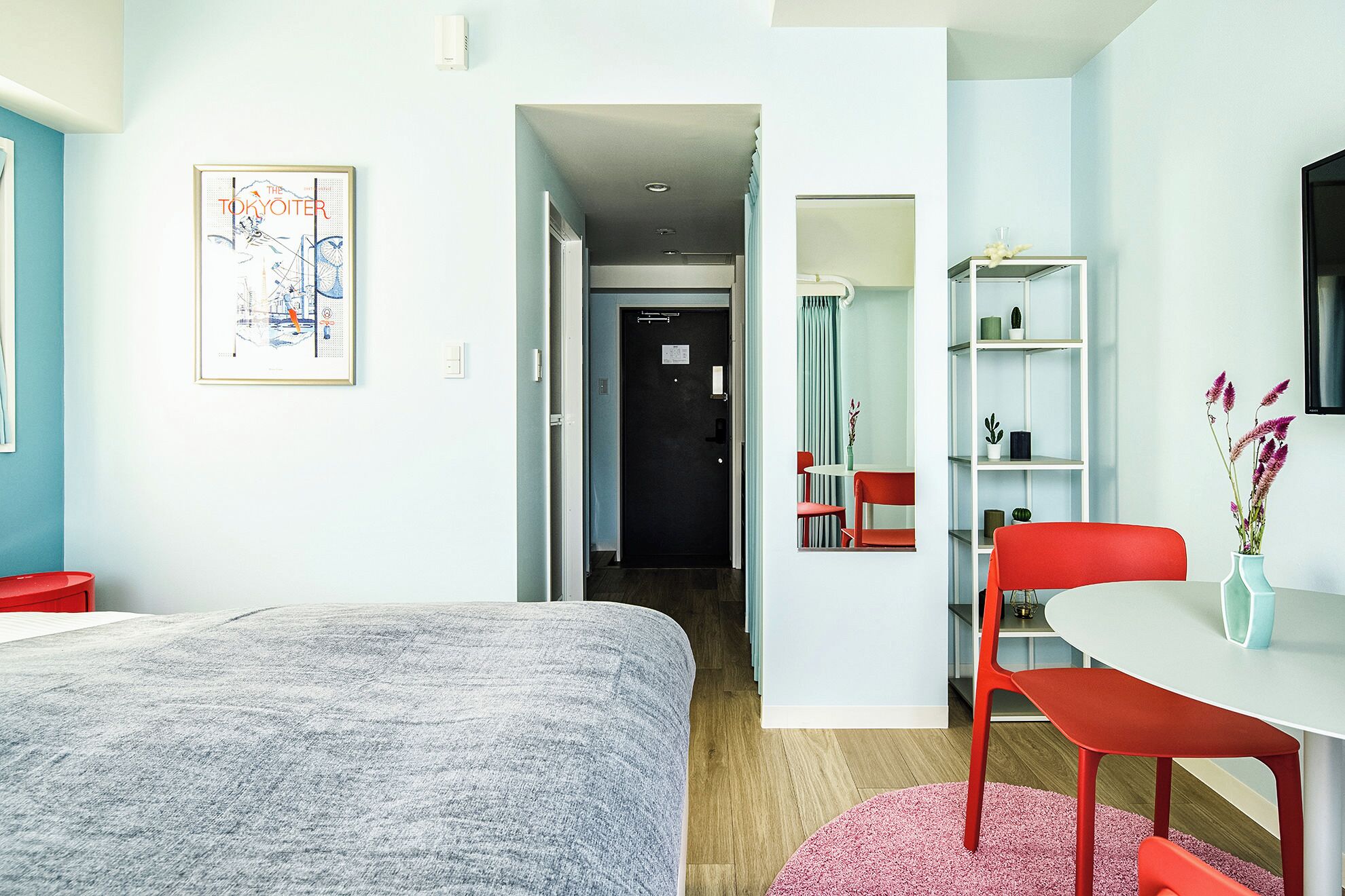 A room with a bed, a desk with a chair, a bookshelf, and a framed picture on the wall.