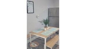 Une petite cuisine équipée avec une table en bois, un banc et une plante en pot.
