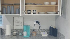 Une cuisine équipée d’un coin café, d’un panneau décoratif encadré et d’une prise de courant.