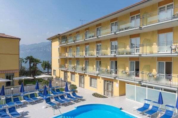 A hotel with a pool area, multiple balconies, and a view of the mountains. - Hotel Drago by Double Hospitality (Brenzone sul Garda)