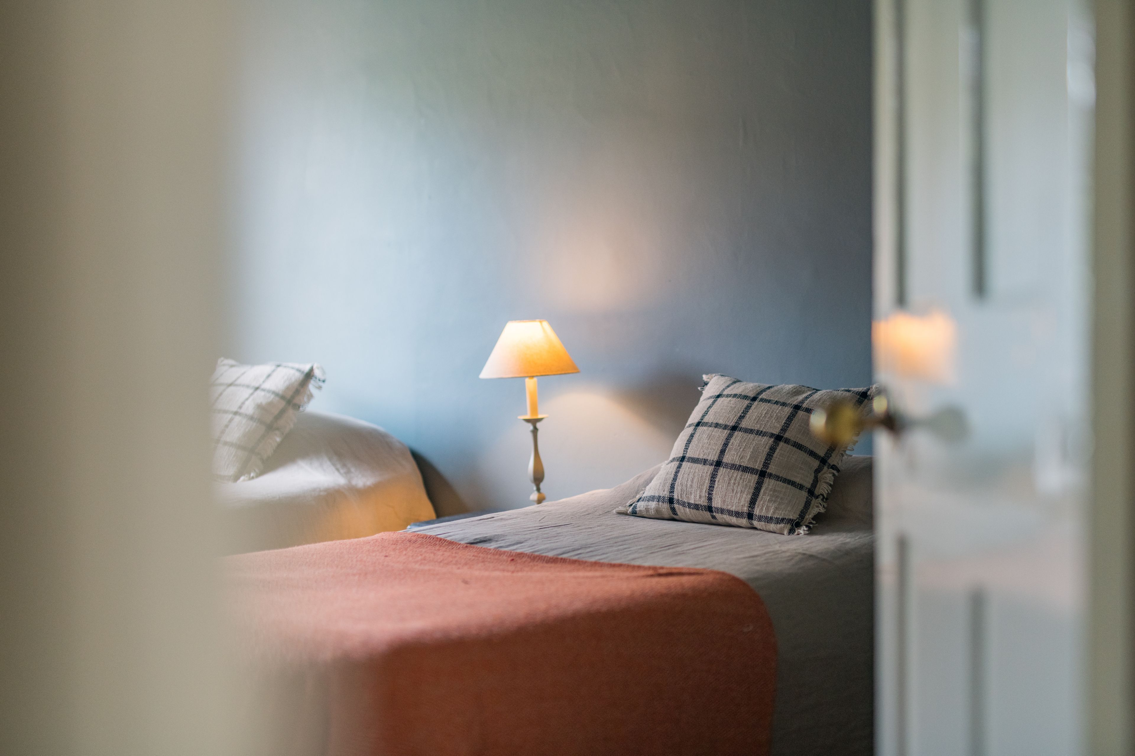 Una camera da letto con un letto, una lampada da comodino e una finestra.