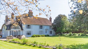 A large, light blue house with a wrap-around porch and a well-maintained lawn. - Craythornes -  a holiday let by Bloom Stays that sleeps 18 guests  in 5 bedrooms (New Romney)