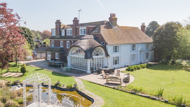 A large house with a garden, a pond, and outdoor furniture. - Craythornes -  a holiday let by Bloom Stays that sleeps 18 guests  in 5 bedrooms (New Romney)