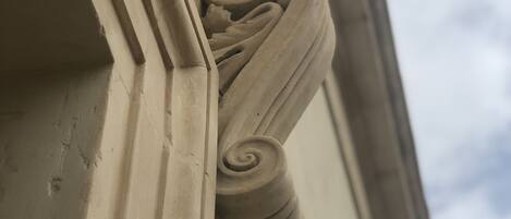 A close-up of a building's corner with a decorative stone carving.