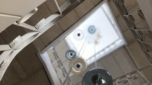 A ceiling with a skylight, a light fixture, and a ventilation system. - De Guidani Experience (Lecce)