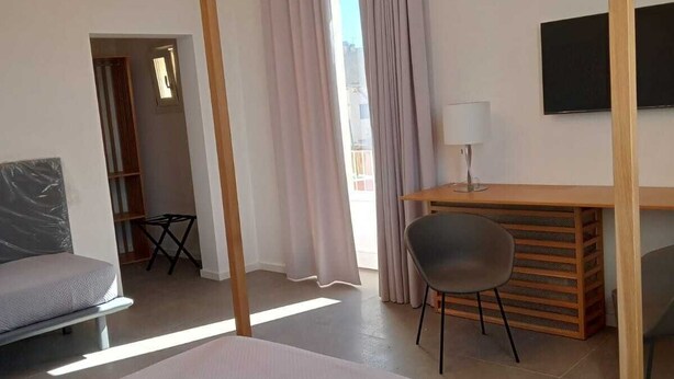 A modern hotel room with a bed, a desk, and a TV. - De Guidani Experience (Lecce)