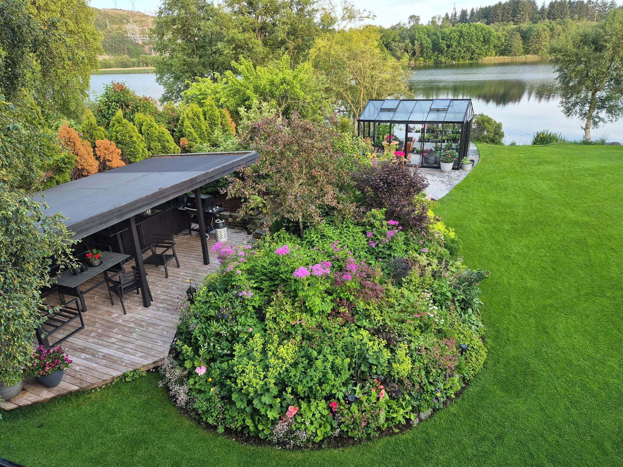 A landscaped garden with a wooden deck, a gazebo, and a pond.