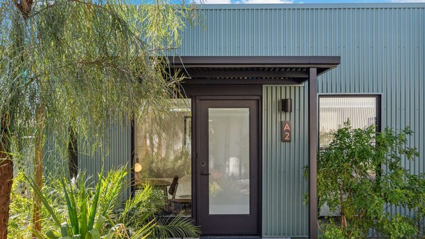 Un bâtiment moderne avec une porte sombre, un petit porche et une enseigne portant le chiffre « 2 ».