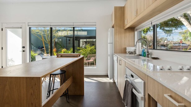 A modern kitchen with wooden cabinets, a large window, and a view of the outdoors. - Refreshing 2-bedroom Container - 80 Walkscore! (Phoenix)