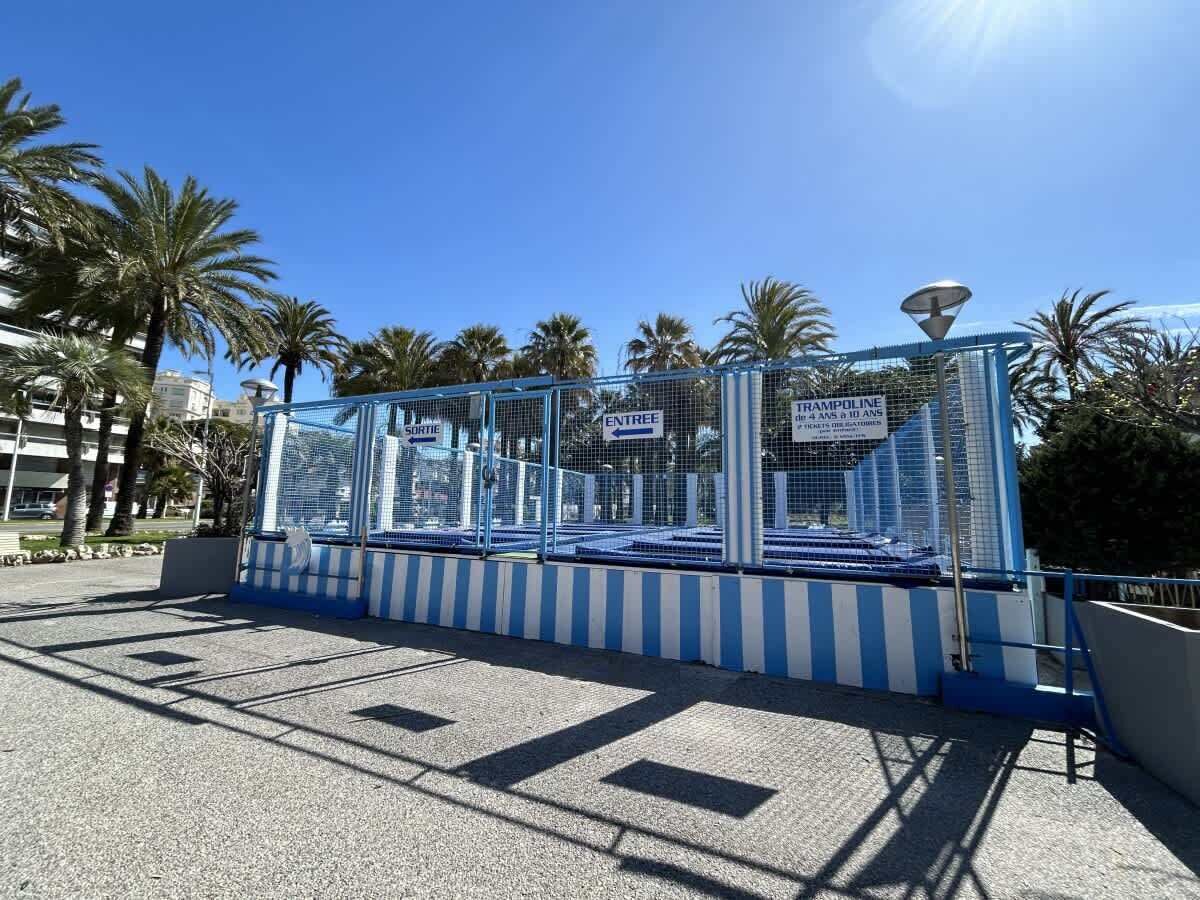 Zona cercada con carteles que indican 'ENTREE' y 'TRAMPOLINE' para mayores de 4 años.