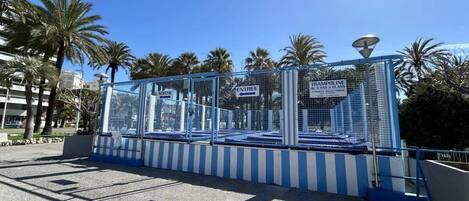 Zona cercada con carteles que indican 'ENTREE' y 'TRAMPOLINE' para mayores de 4 años.