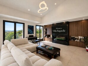 Uma sala de estar moderna com um sofá, uma mesa de centro, um piano e uma lareira.