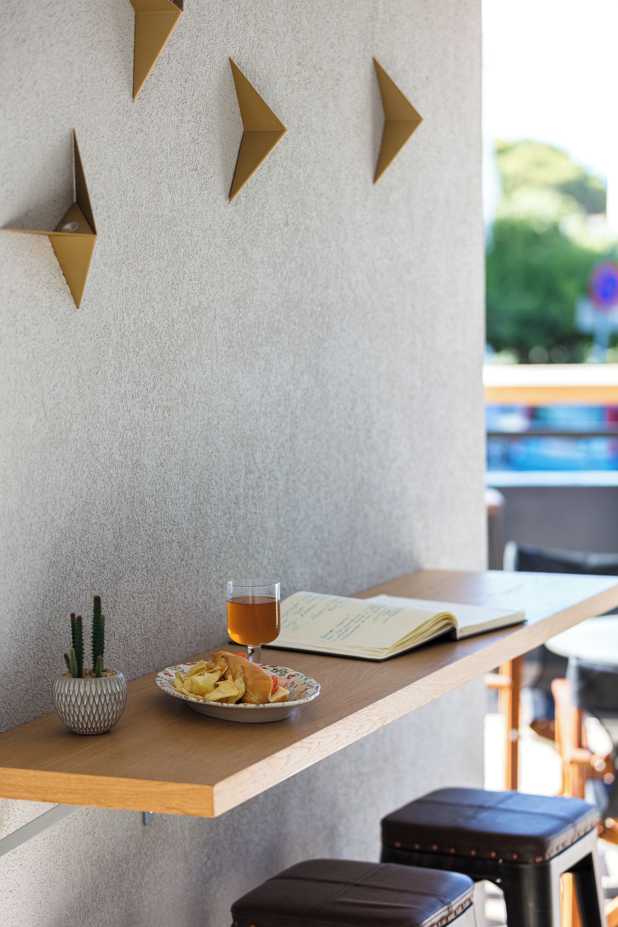A table with a plate of food, a glass of drink, and a menu. There is a cactus plant on the table.