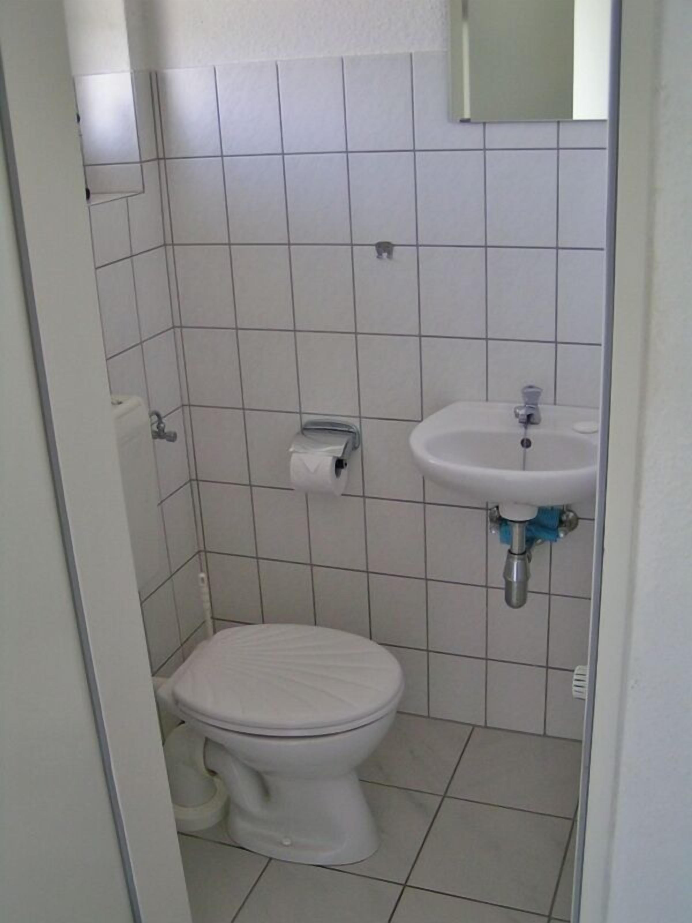 Une petite salle de bain propre, avec des toilettes et un lavabo.