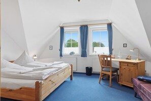 A bedroom with a bed, a desk, a chair, and a window with curtains. - Ruhig Gelegenes Mittelhaus in Greetsiel (Greetsiel)