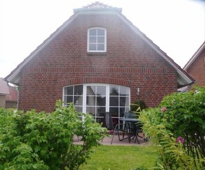 Stunning residential building with a brick facade, arched window, and lush green surroundings.