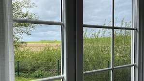A window with a view of a field and a fence. - Beautiful vacation home in a cul-de-sac location with unobstructed views (Greetsiel)