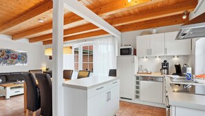 A compact kitchen with white cabinets, a microwave, a coffee maker, and a dishwasher. - Wunderschönes Ferienhaus mit Eigenem Tretboot (Greetsiel)
