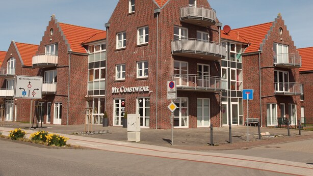 Ein Gebäude aus roten Ziegeln mit einem Schild, auf dem "My Coastwear" steht.