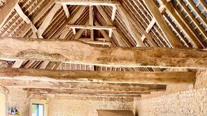 Une piscine intérieure avec un mur en pierre et des poutres en bois au plafond.
