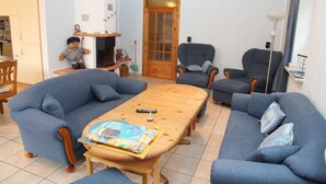 Een woonkamer met een houten tafel, twee banken en een stoel.