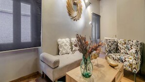 Ein modernes Wohnzimmer mit einer Couch, einem Couchtisch und einer dekorativen Vase.