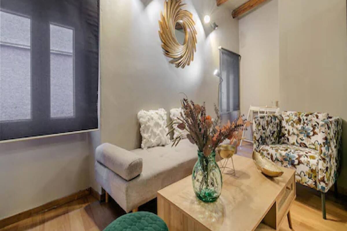 Un salon moderne avec un canapé, une table basse et un vase décoratif.