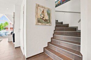Eine Treppe mit Holzdielen und einem Gemälde eines Segelbootes an der Wand.